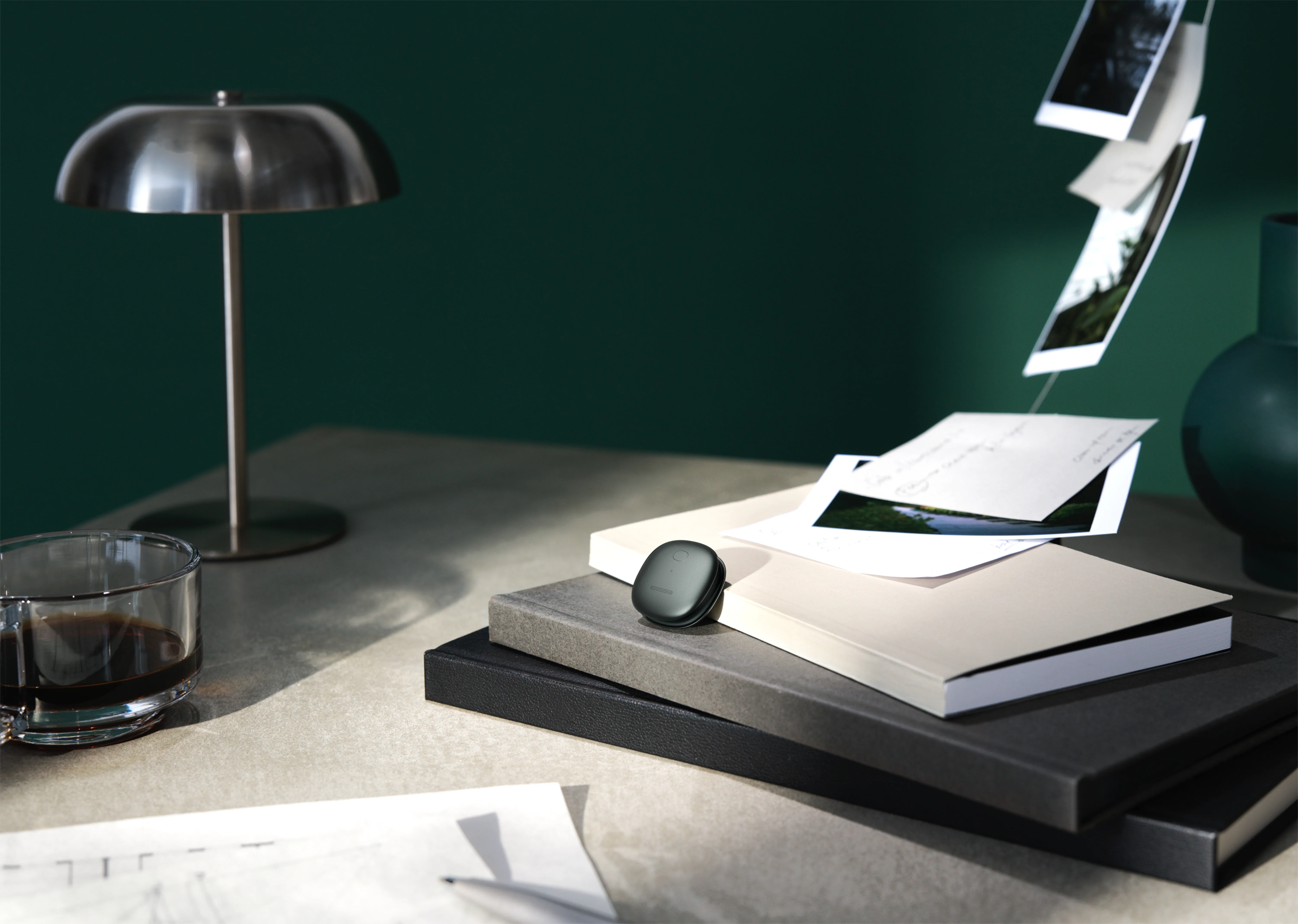 The Mori device on a desk, among notebooks, photos, and coffee